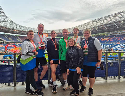 Eine Gruppe von Leuten posiert für ein Gruppenfoto in einer Fußballarena