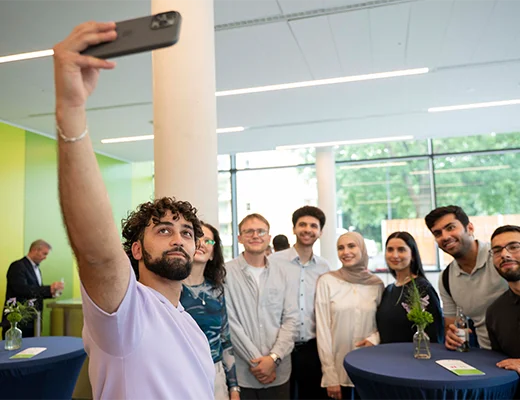 Eine Gruppe junger Menschen steht zusammen, einer macht ein Selfie von der Gruppe
