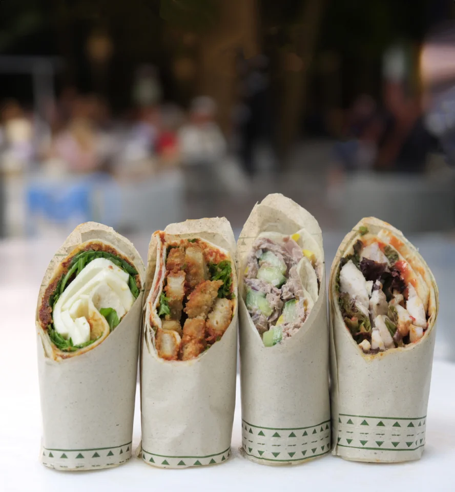 Vier aufgeschnittene Wraps stehen aufrecht vor der Kamera