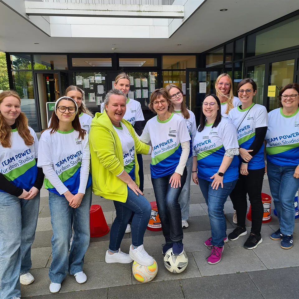 Eine Gruppe von Personen steht vor einem Gebäude