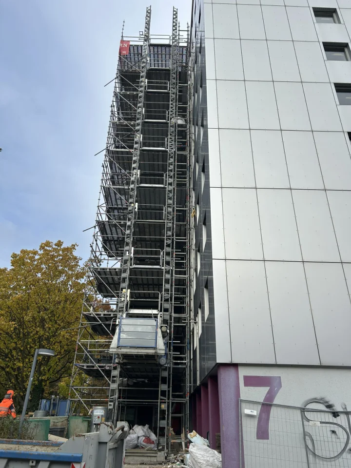 eingerüstetes elfstöckiges Wohnheim mit silberner Fassade 