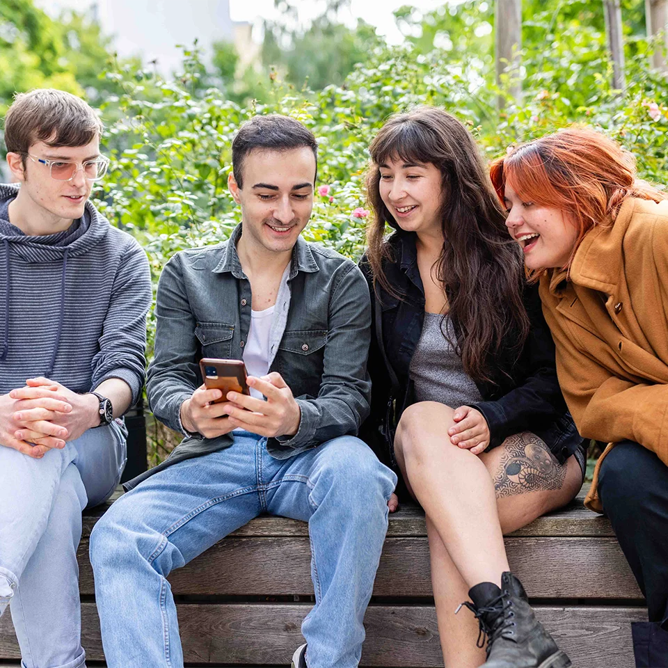 Eine Gruppe von jungen Personen sitzt auf einer Bank